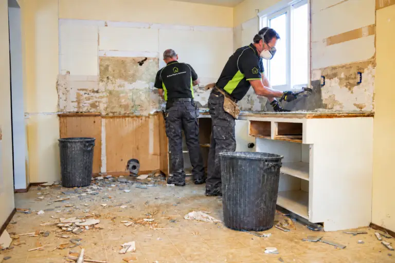 Two engineers in company uniform working on a kitchen renovation